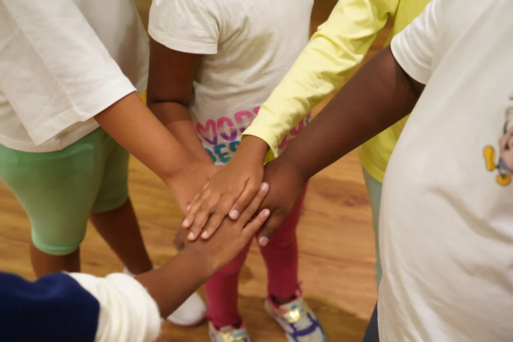 Children stacking hands together during a team activity
